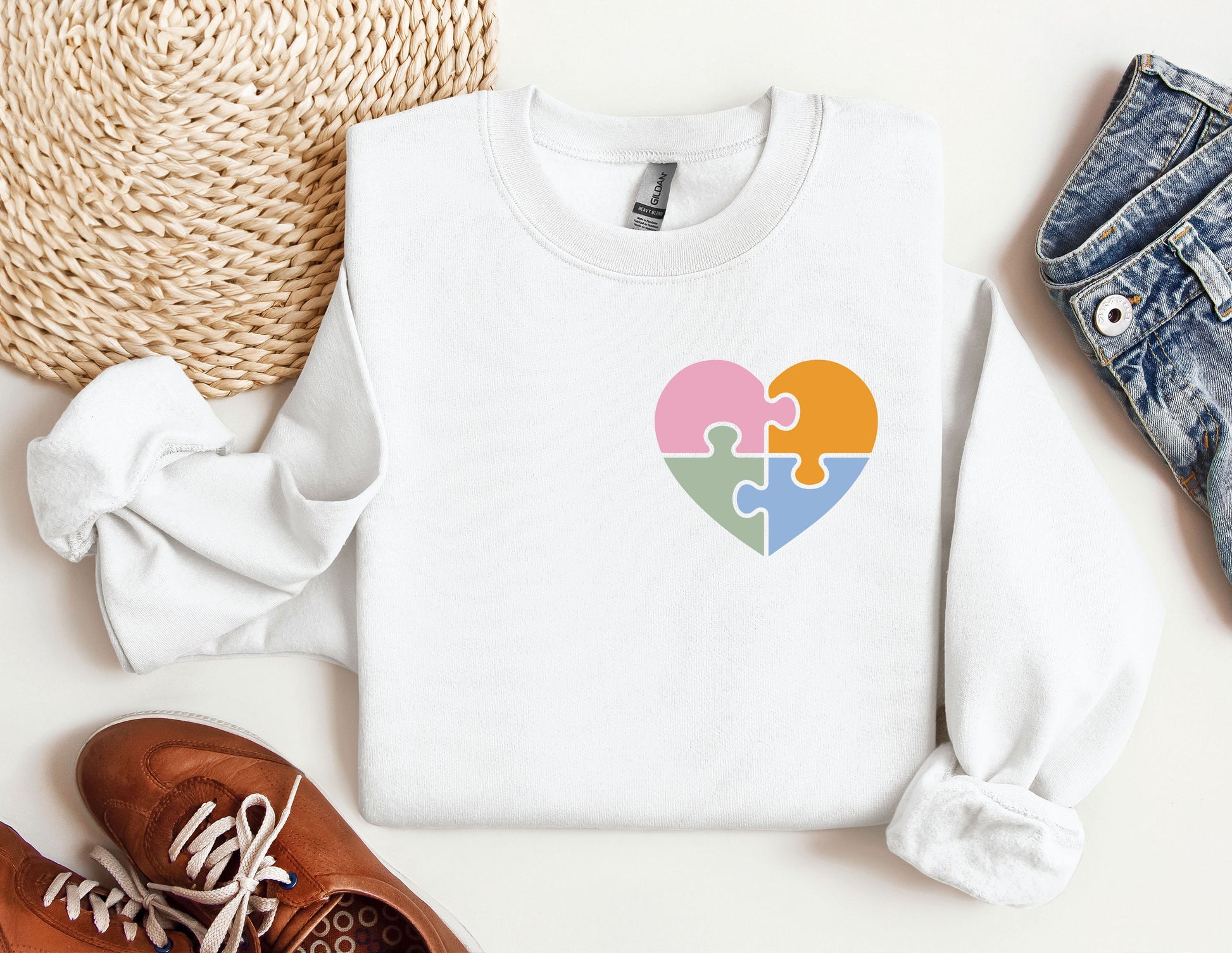 a white sweater with a puzzle heart on it