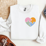 a white sweater with a puzzle heart on it
