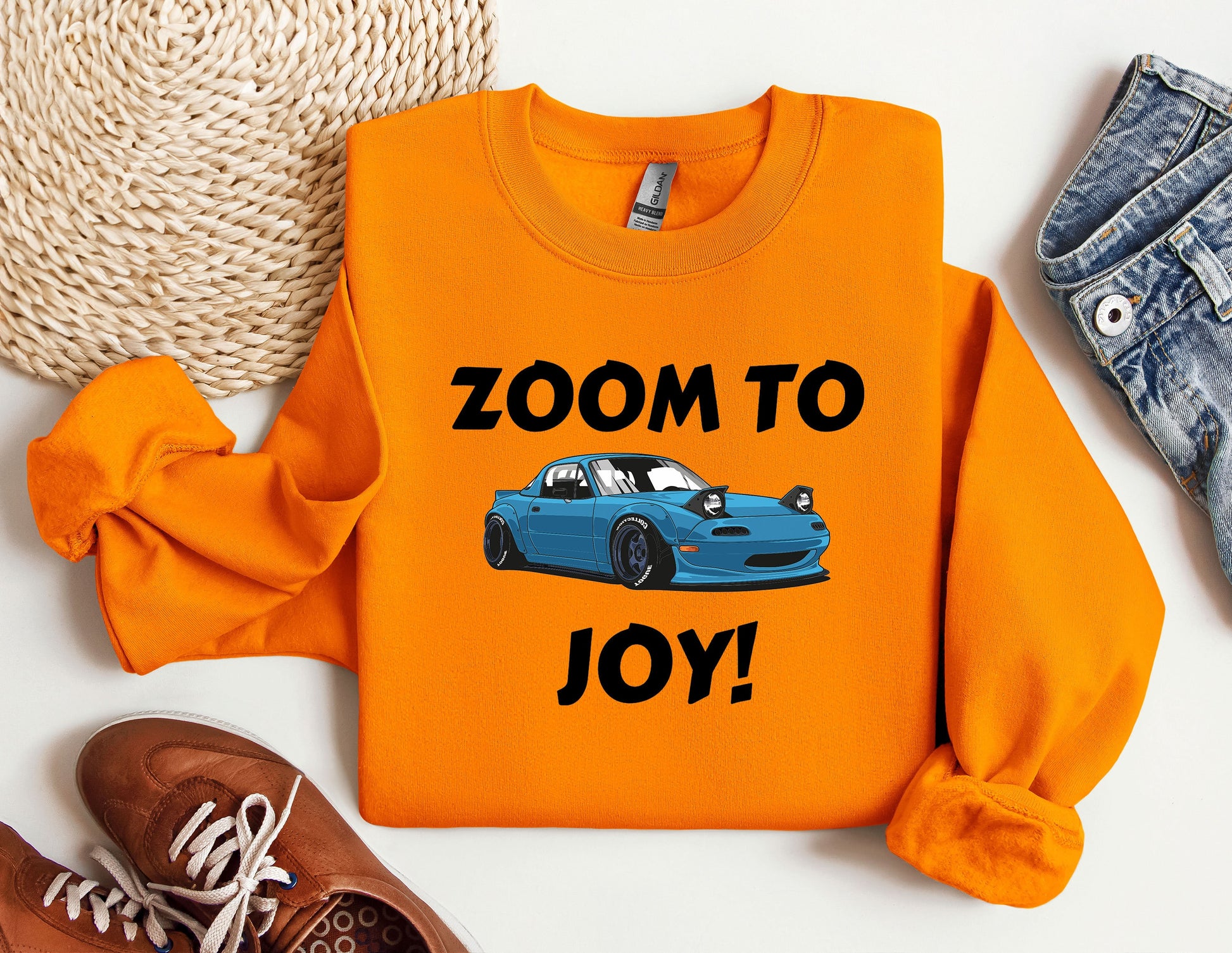 an orange shirt with a blue car that says zoom to joy