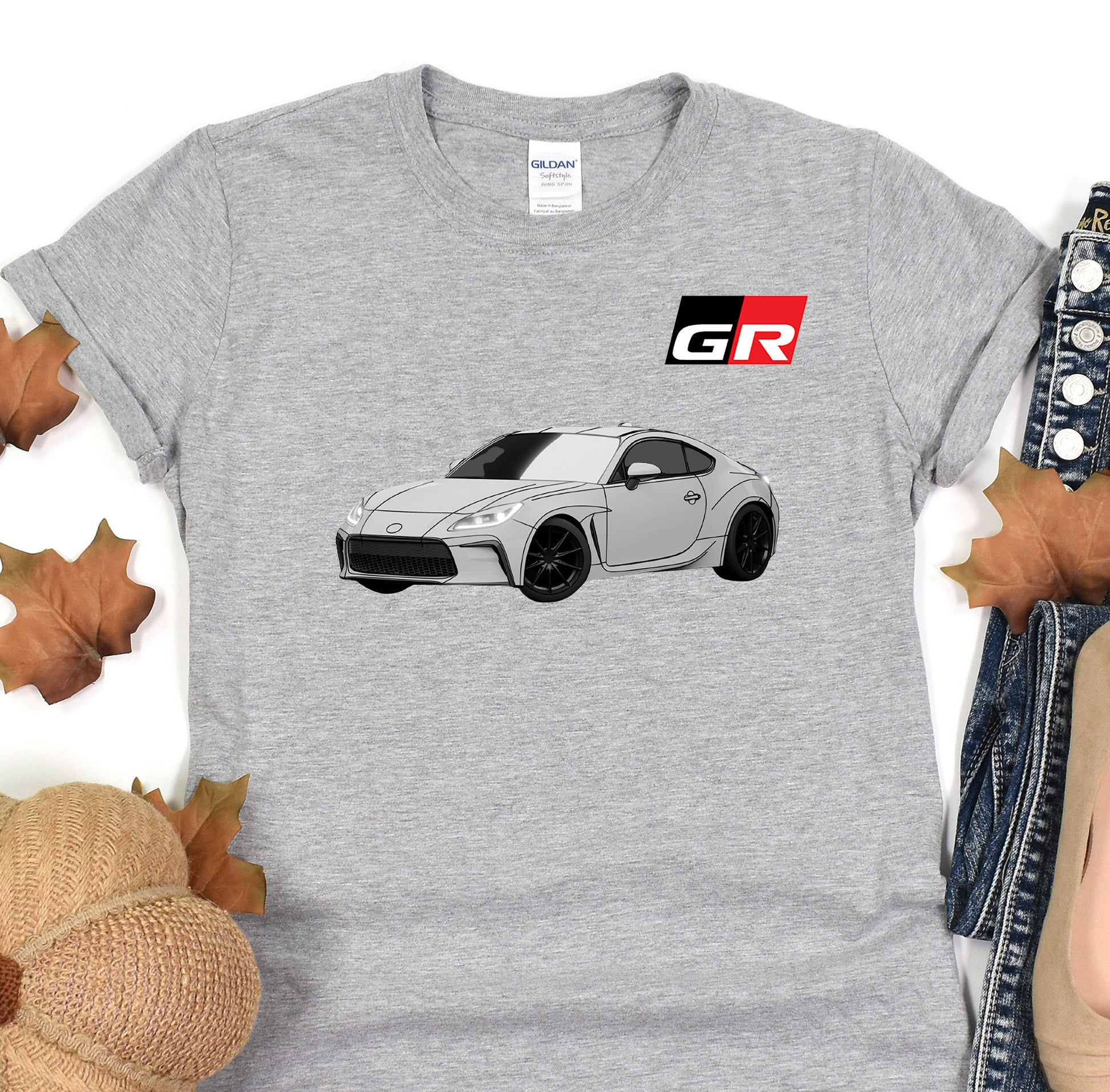 a gray t - shirt with a picture of a car on it