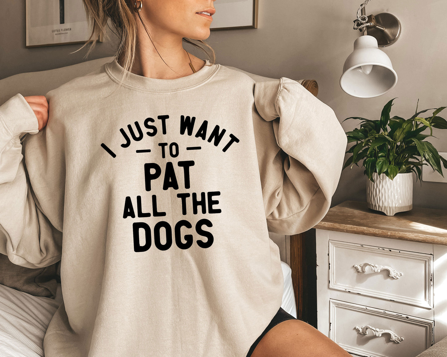 a woman wearing a sweatshirt that says i just want to pat all the dogs