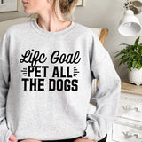 a woman wearing a sweatshirt that says life goal pet all the dogs