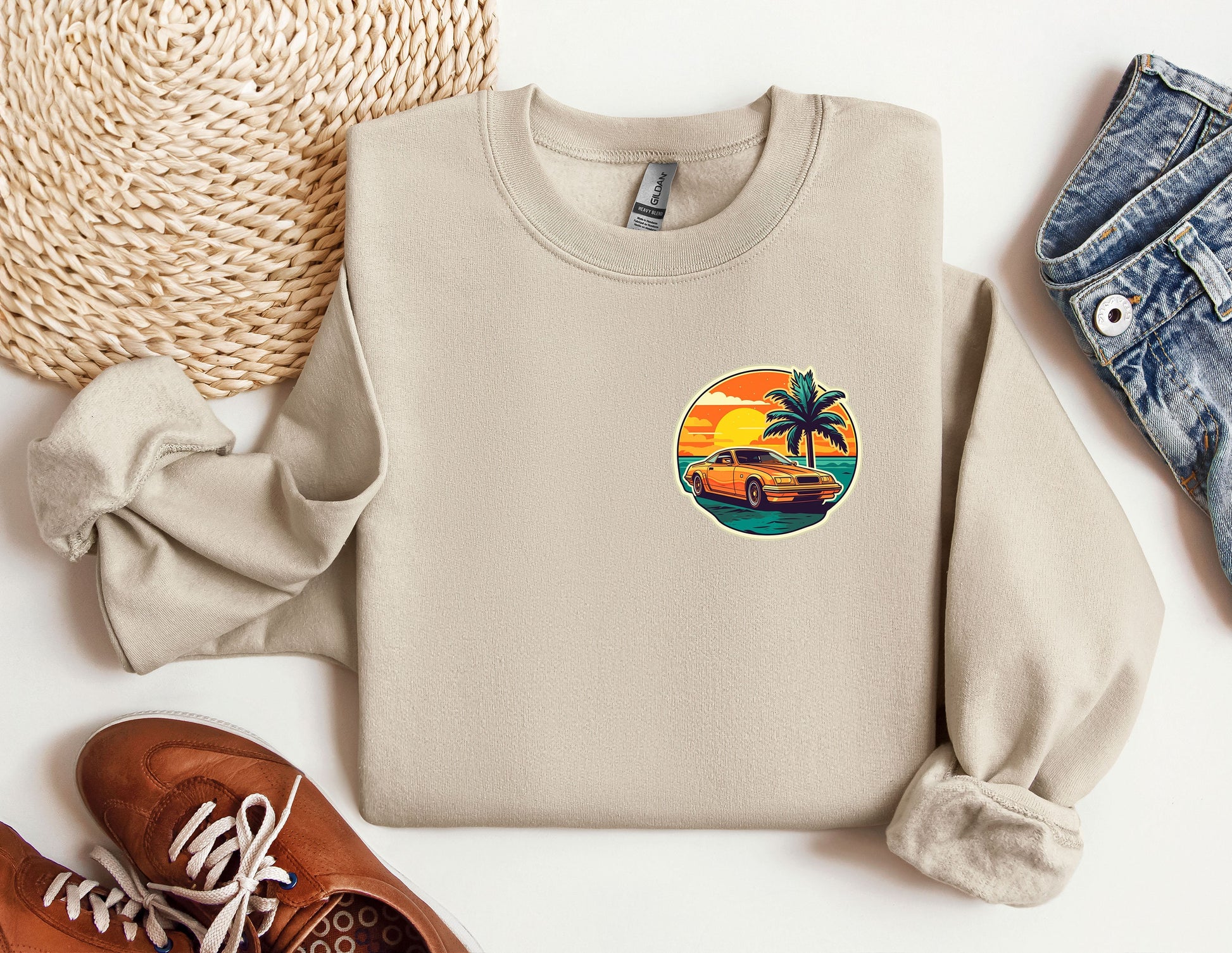 a sweater with a palm tree on it next to a pair of shoes