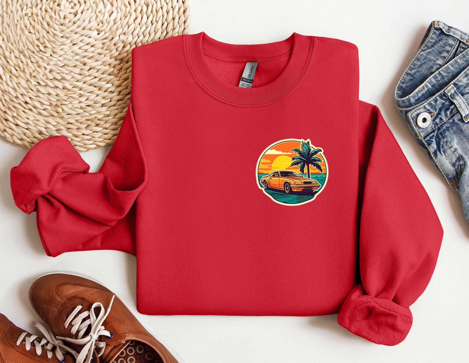 a red sweatshirt with a palm tree and a car on it