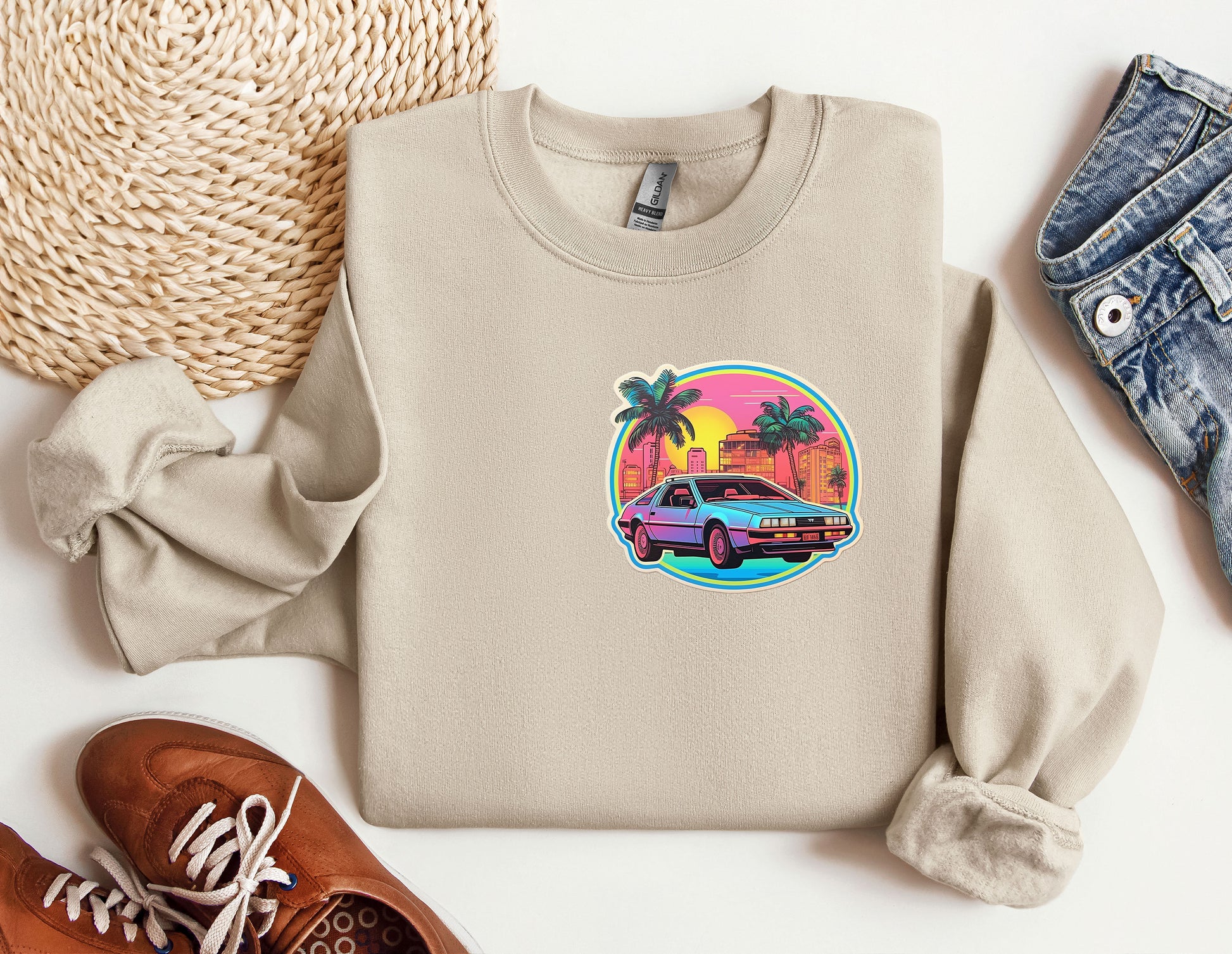 a sweater with a car on it next to a pair of shoes