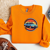 an orange shirt with a car on it next to a pair of shoes