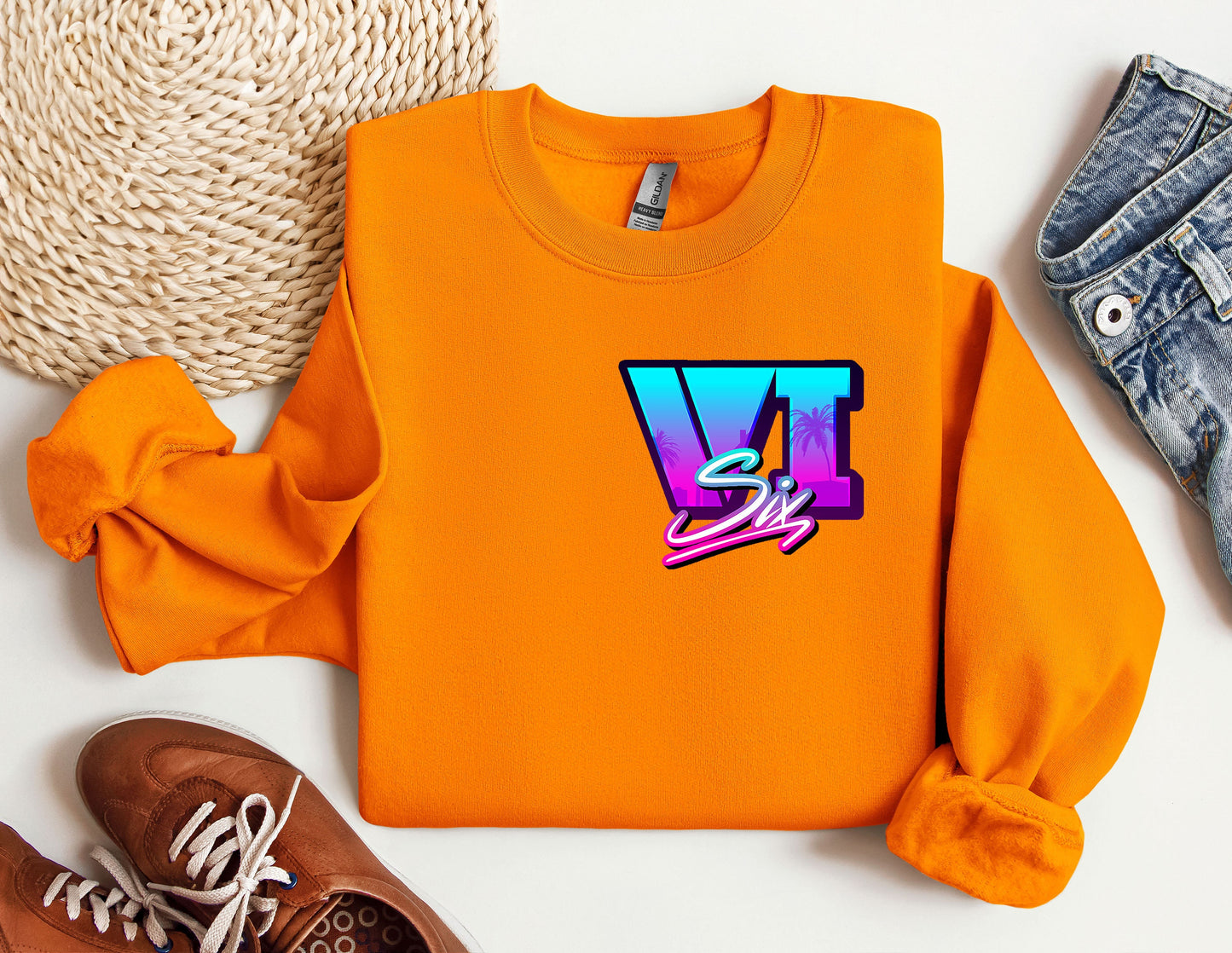 a pair of shoes and an orange sweatshirt on a white surface