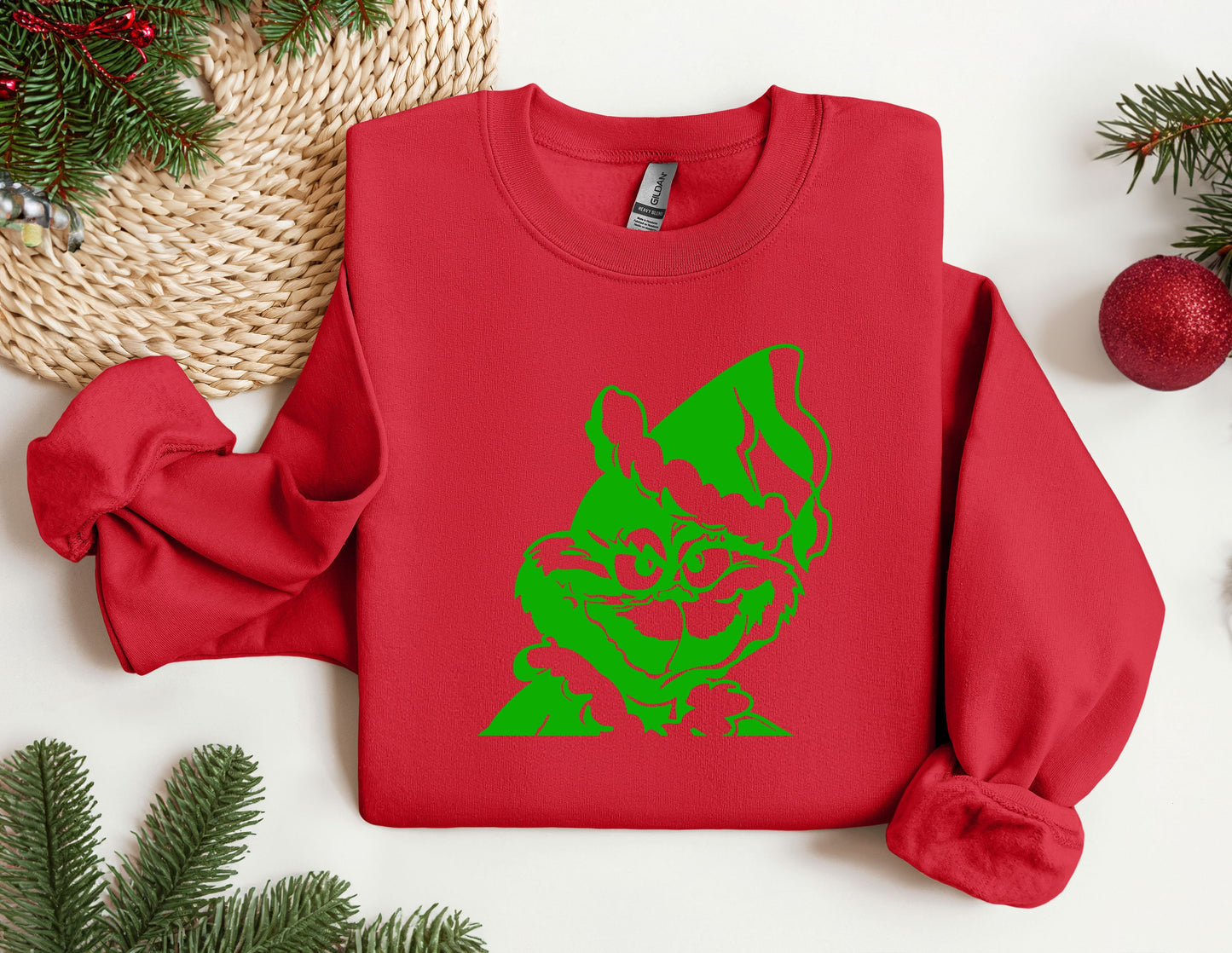 a red sweater with a green cat on it