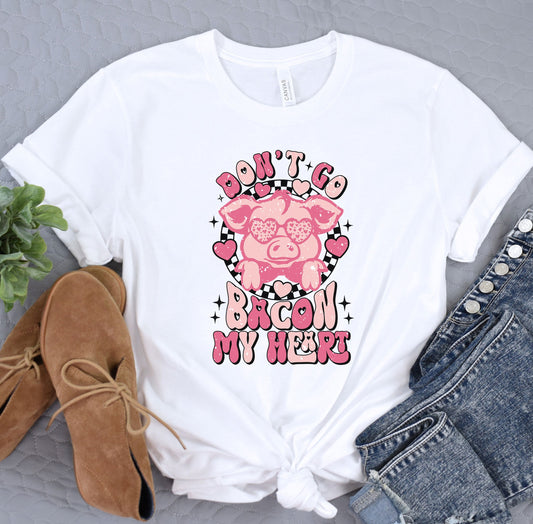 a white shirt with a pink pig on it