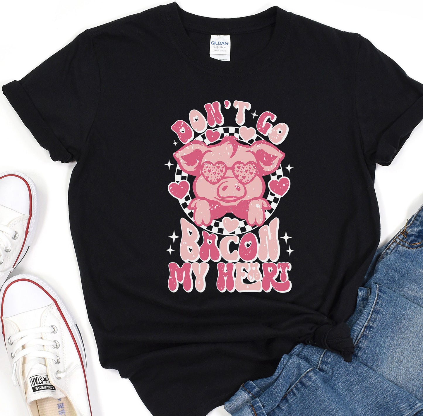 a black shirt with a pink pig on it