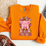 an orange shirt with a pig on it next to a pair of shoes