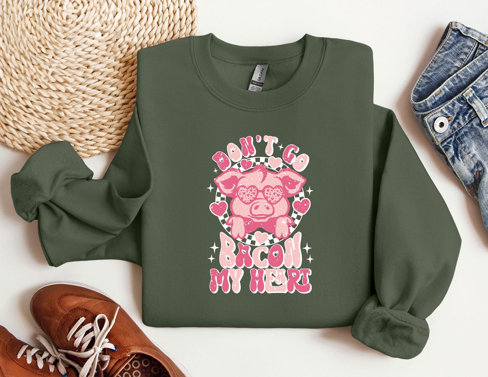 a green sweatshirt with a pink pig on it