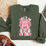 a green sweatshirt with a pink pig on it