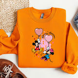 a pair of sneakers and a sweatshirt with mickey mouse on it