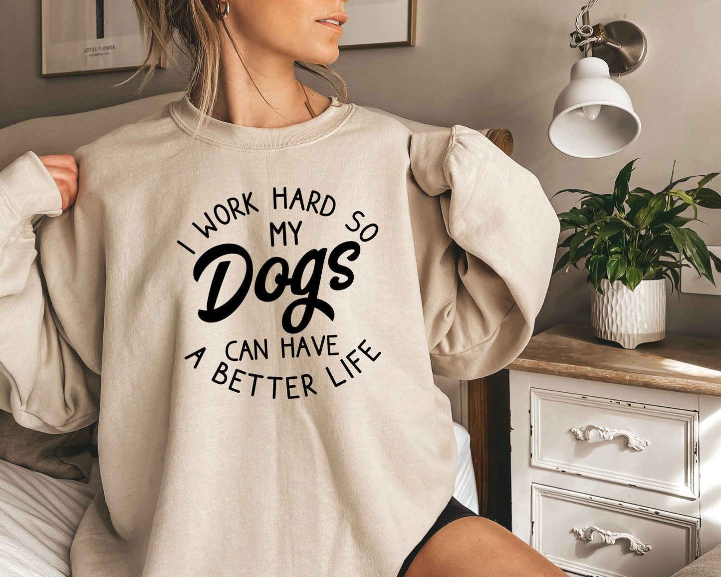 a woman wearing a sweatshirt that says i work hard so my dogs can have a