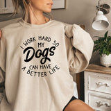 a woman wearing a sweatshirt that says i work hard so my dogs can have a