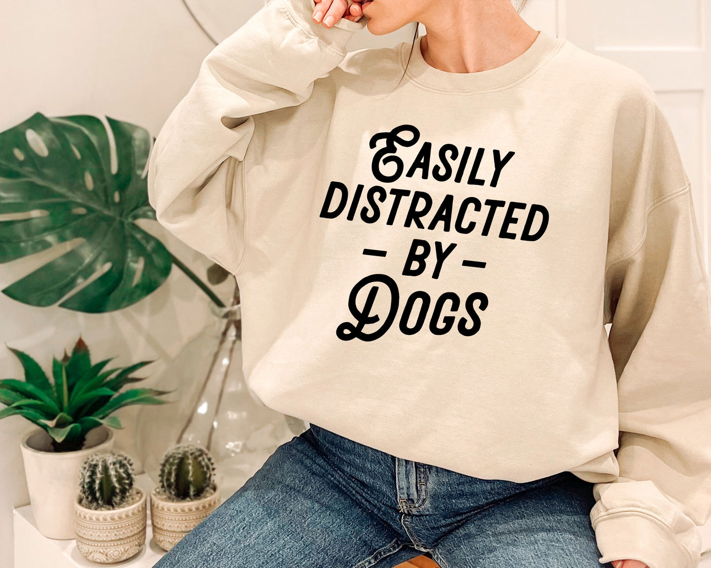 a woman wearing a sweatshirt that says easily distracted by dogs