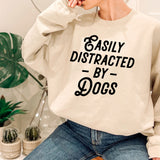 a woman wearing a sweatshirt that says easily distracted by dogs