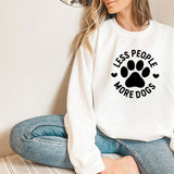 a woman sitting on the floor wearing a sweatshirt with a dog's paw on