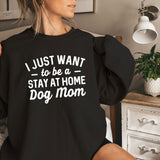 a woman sitting on a bed wearing a black sweatshirt that says i just want to