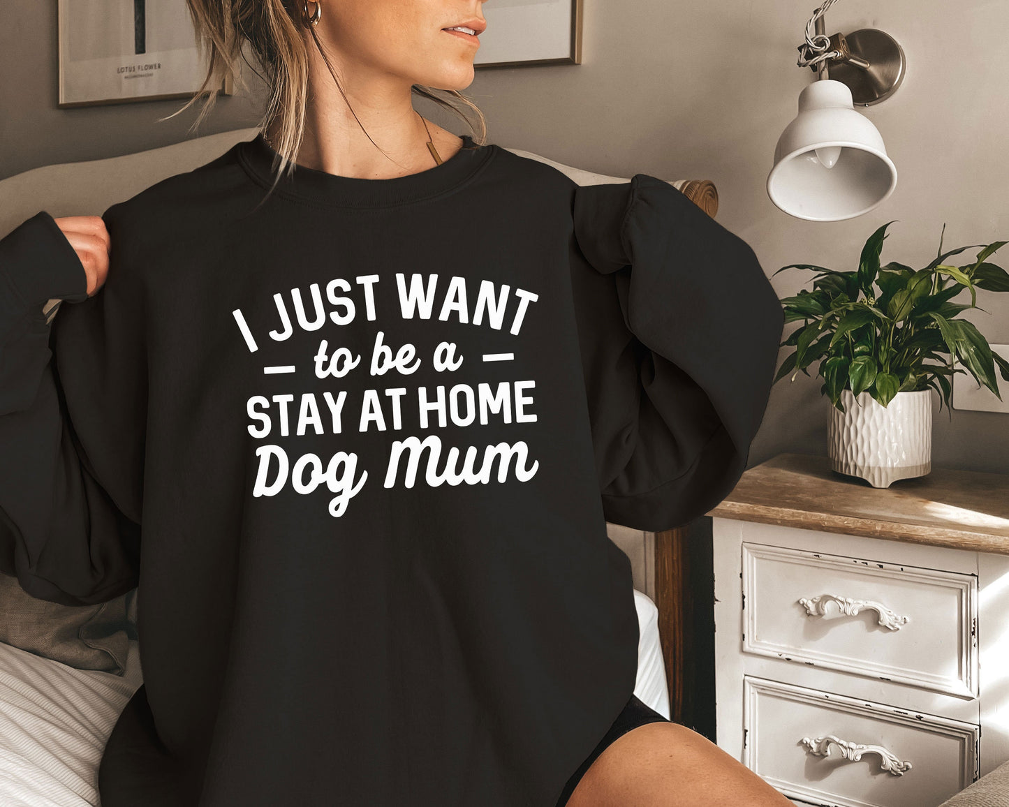 a woman sitting on a bed wearing a black shirt that says i just want to