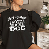 a woman sitting on a bed wearing a black sweatshirt