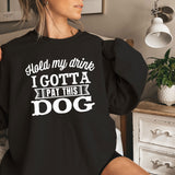 a woman sitting on a bed wearing a black sweatshirt