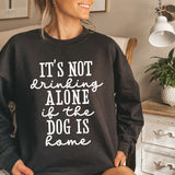 a woman sitting on a bed wearing a black sweatshirt that says it's not