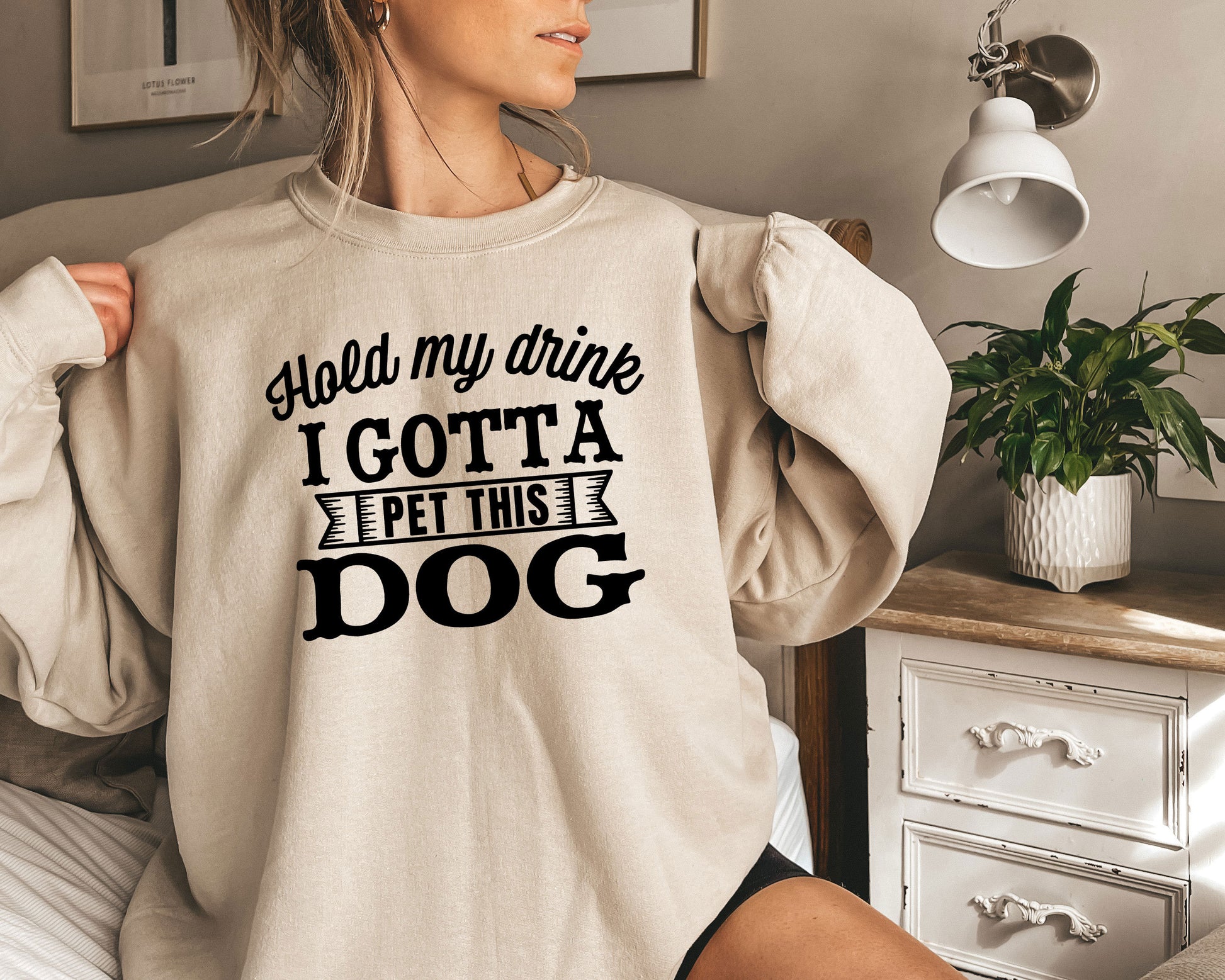 a woman wearing a sweatshirt that says, hold my drink i got a pet this