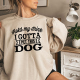 a woman wearing a sweatshirt that says, hold my drink i got a pet this