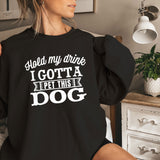 a woman sitting on a bed wearing a black sweatshirt
