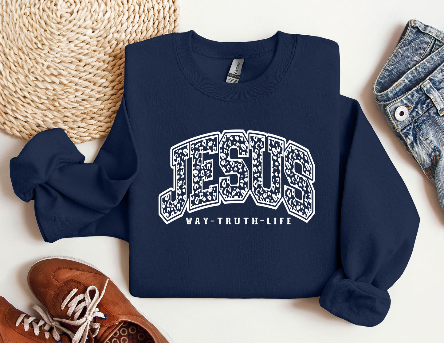 a blue sweatshirt with the word jesus on it next to a pair of sneakers