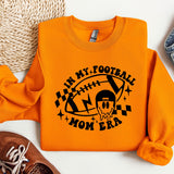 an orange shirt with a football mom on it