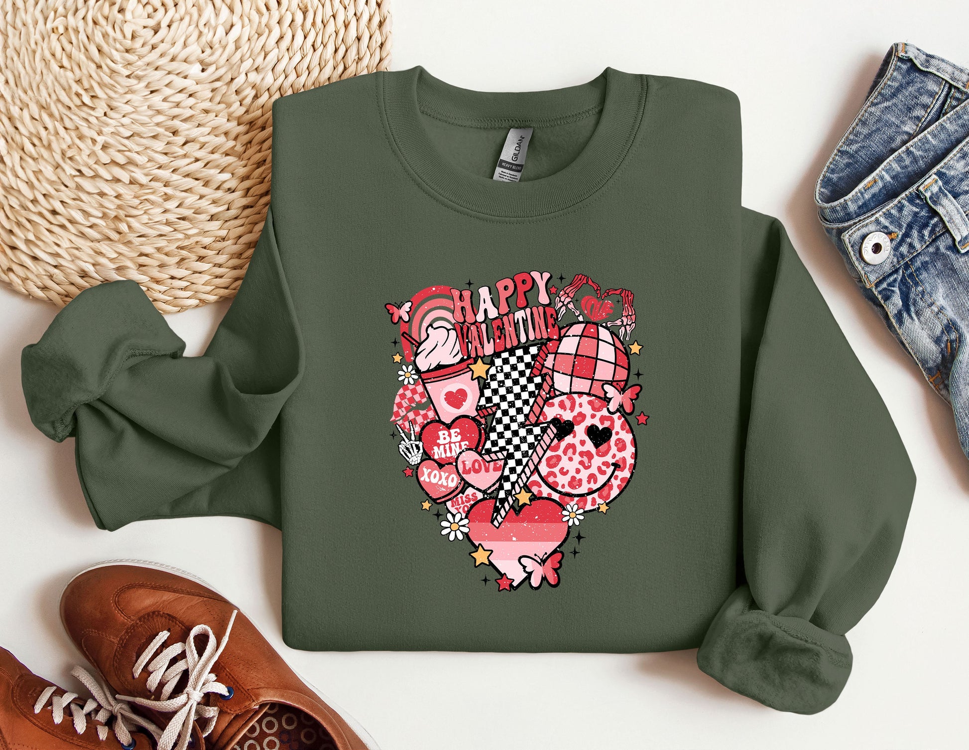 a green sweatshirt with a heart on it next to a pair of shoes