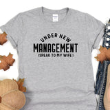 a t - shirt that says under new management speak to my wife