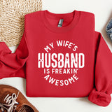 a red sweatshirt that says, my wife's husband is freakin'awesome