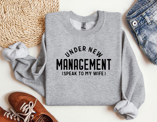 a sweater that says under new management speak to my wife
