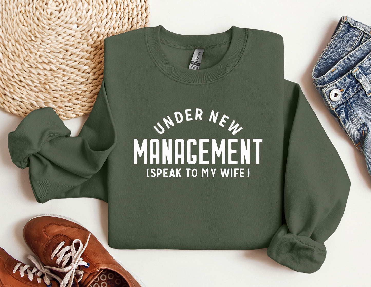 a green sweater that says under new management speak to my wife