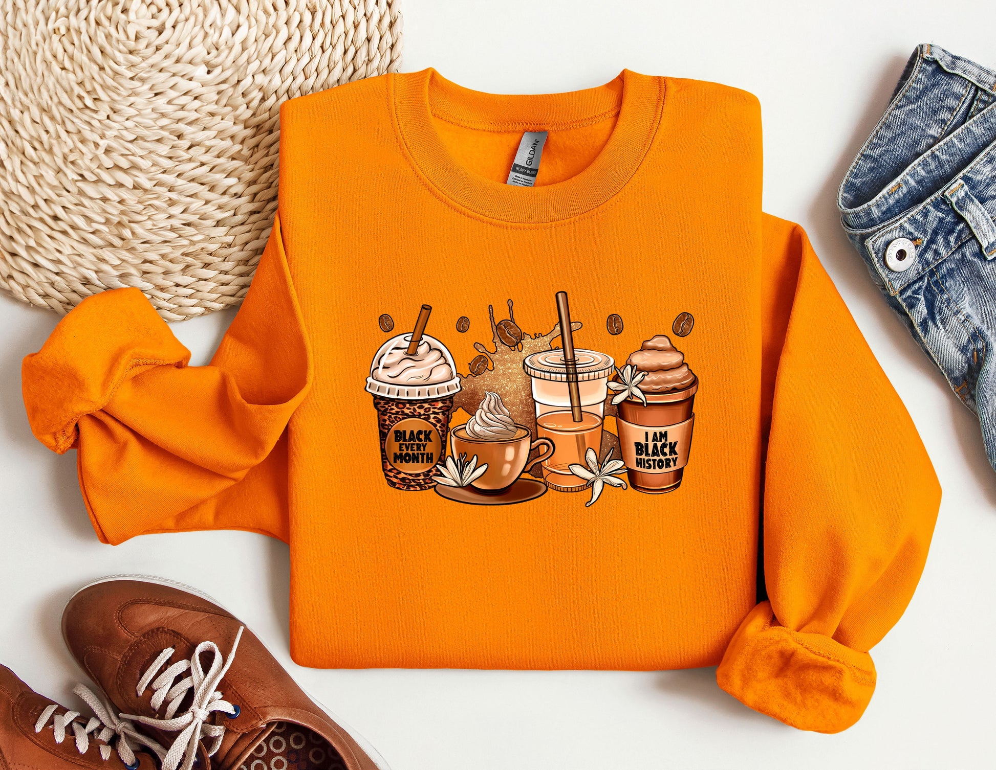 a pair of sneakers and an orange sweatshirt with a picture of two cups of coffee