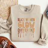 a sweater that says black women glow different colors