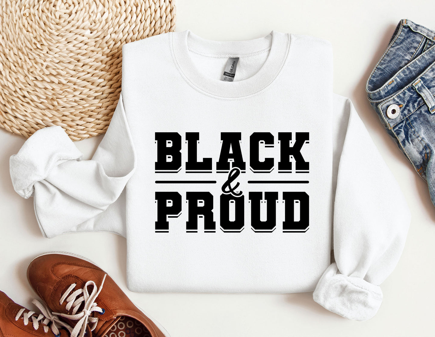 a white shirt that says black and proud next to a pair of shoes