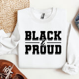 a white shirt that says black and proud next to a pair of shoes