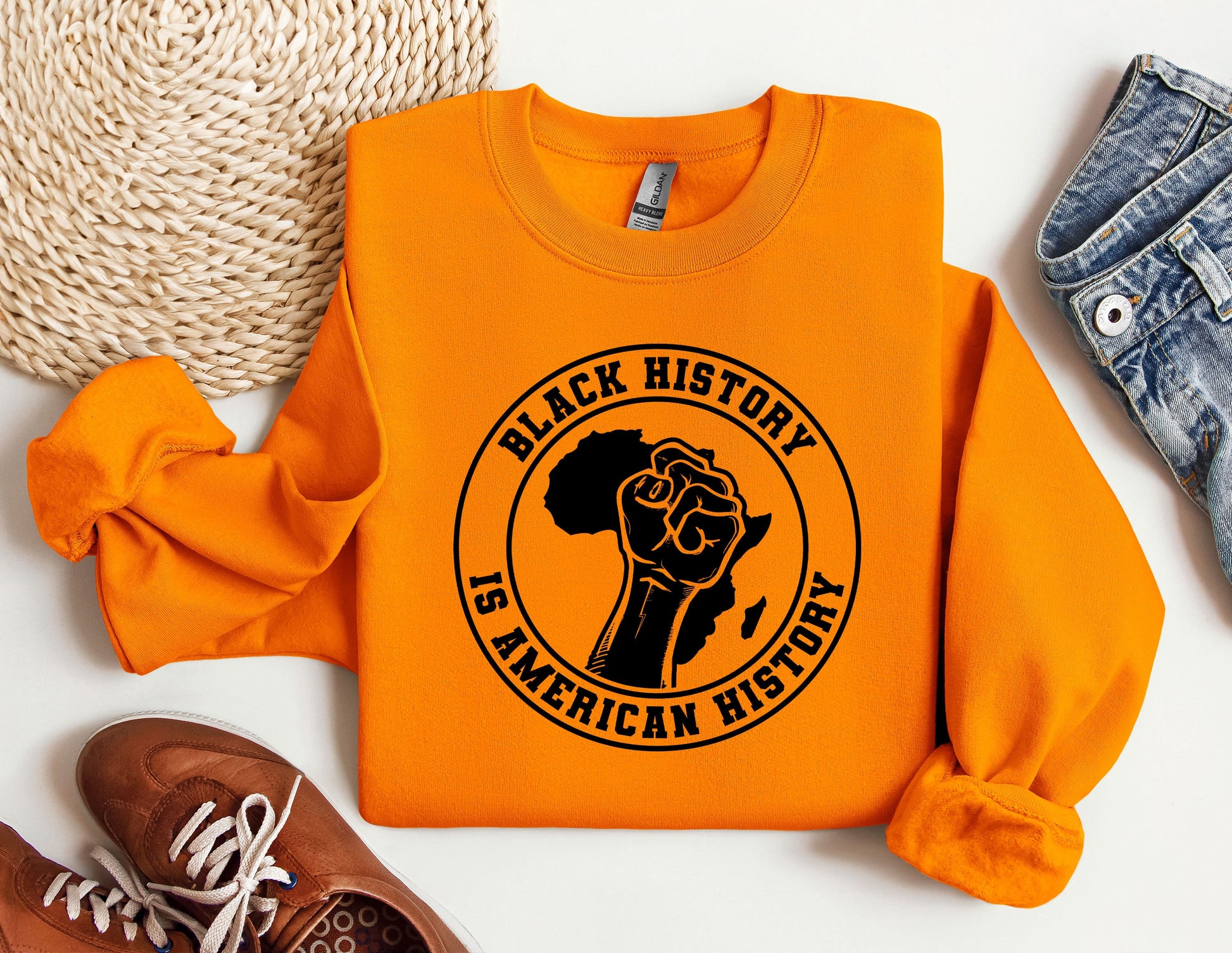 an orange sweatshirt with a black history is american hero on it