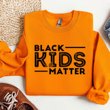 a black kids matter shirt next to a pair of sneakers