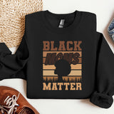 a black man's matter sweatshirt next to a pair of sneakers