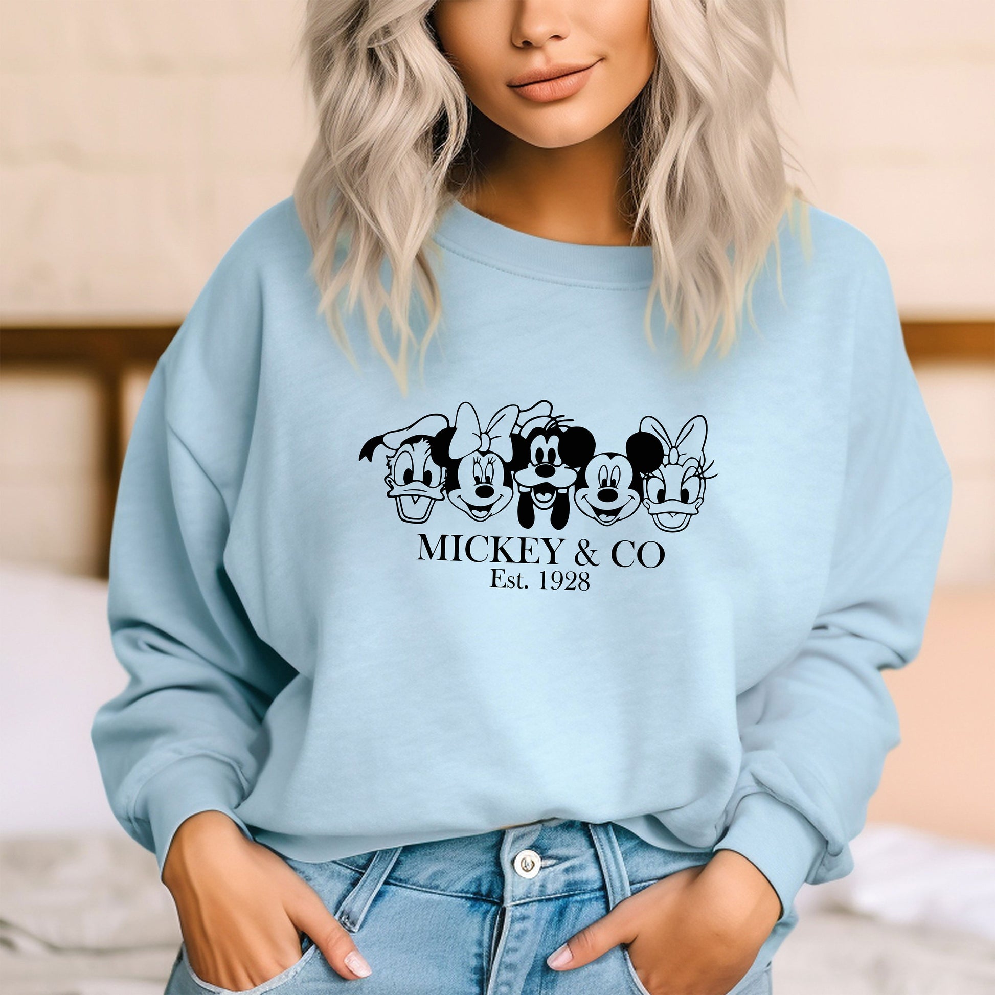 a woman wearing a mickey and mickey mouse sweatshirt