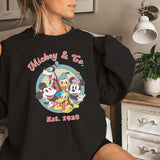 a woman in a mickey and friends shirt on a bed