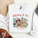 a mickey and mickey mouse sweatshirt next to a pair of shoes