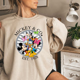 a woman wearing a mickey and minnie mouse sweatshirt