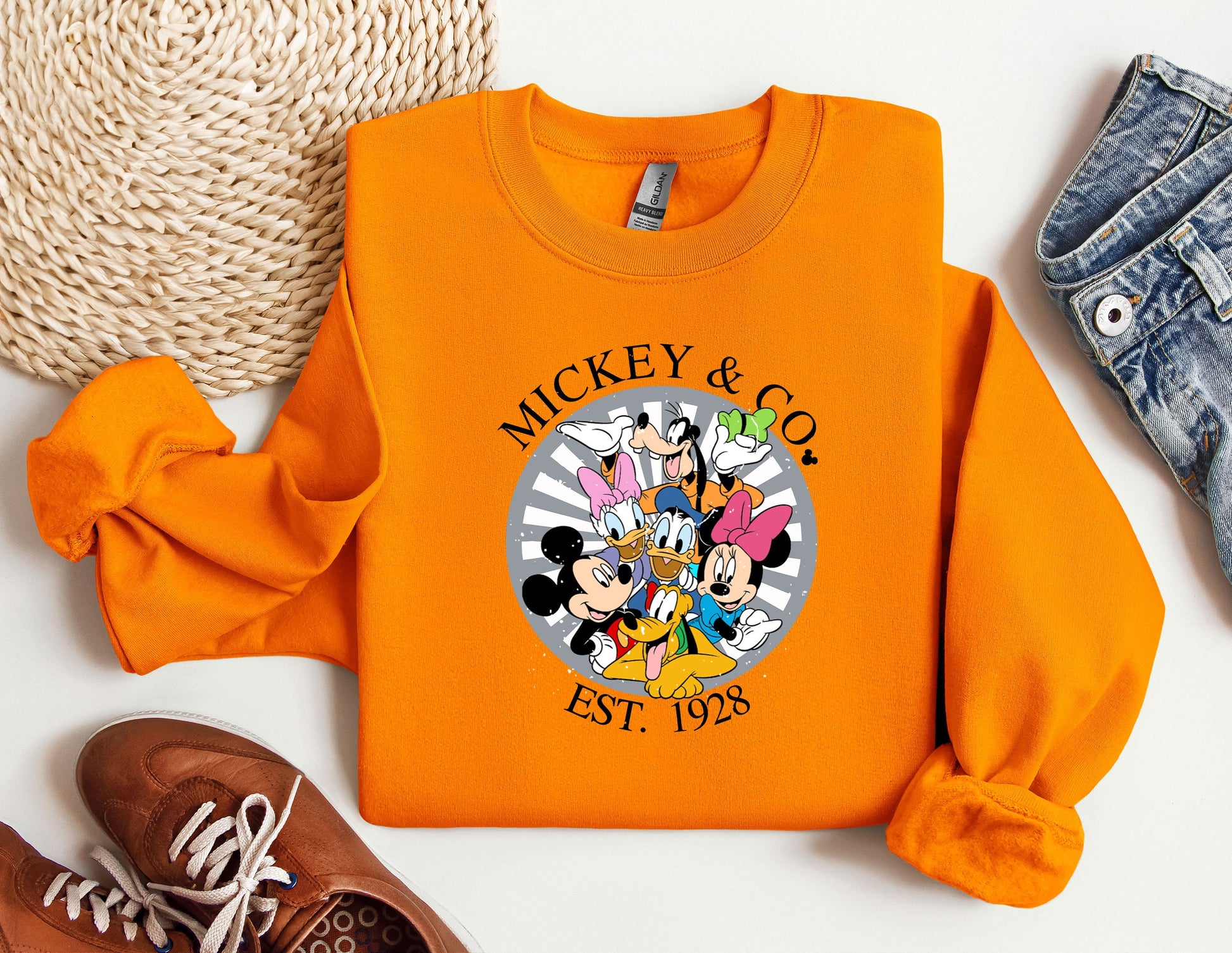 an orange mickey and mickey mouse shirt next to a pair of sneakers